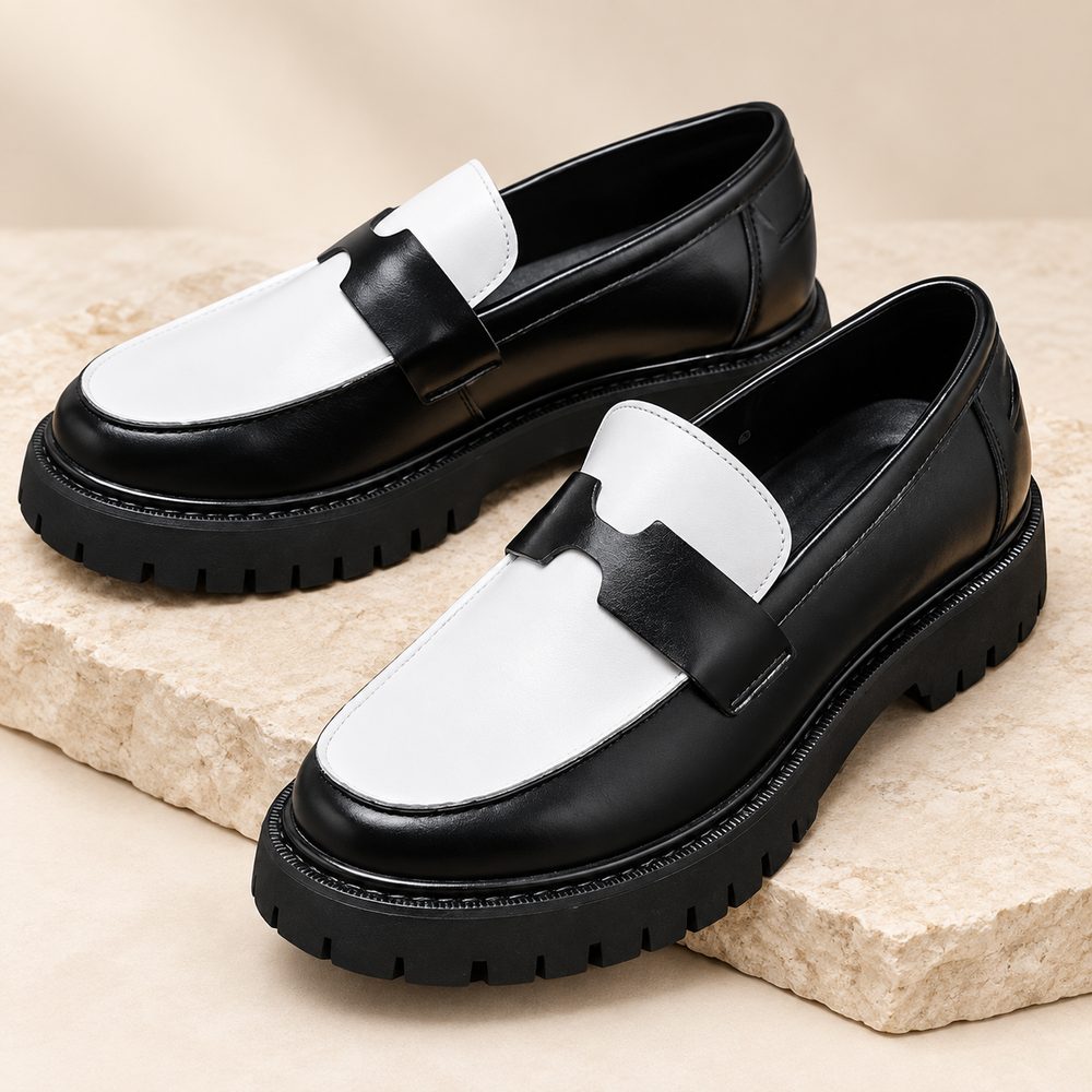 Mocassin noir et blanc à semelle crantée, photographié sur une dalle de pierre claire