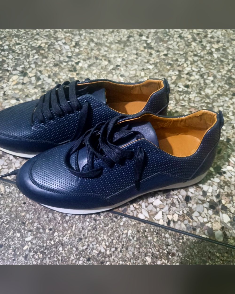 Sneaker Ganvié en cuir marine perforé, laçage plat, vue de trois quarts